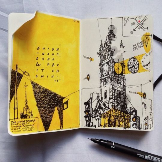Ein offenes Skizzenbuch mit verschiedenen Zeichnungen und Kunstbedarf auf einem Tisch